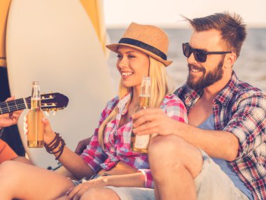 couple holding bottles with beer