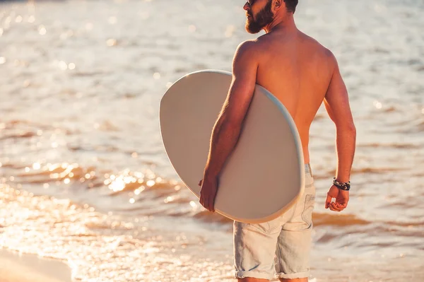 Shirtless young man holding skimboard — Stock Photo, Image