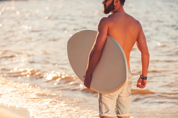 Jovem sem camisa segurando skimboard — Fotografia de Stock