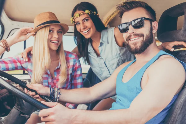 Women and man sitting inside of minivan — Stockfoto