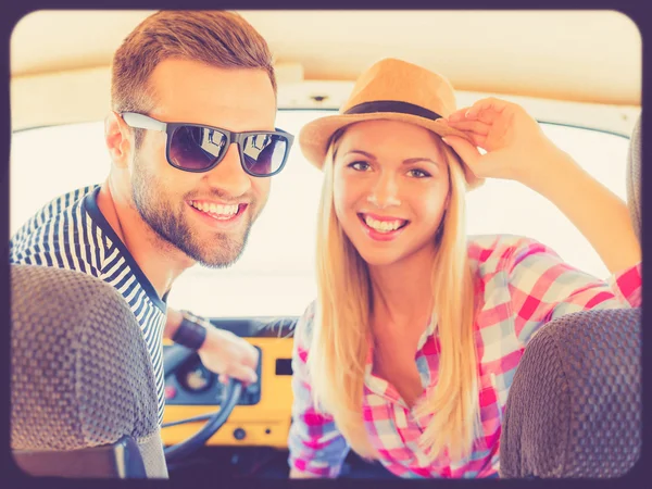 Casal sorrindo e sentado dentro do carro — Fotografia de Stock