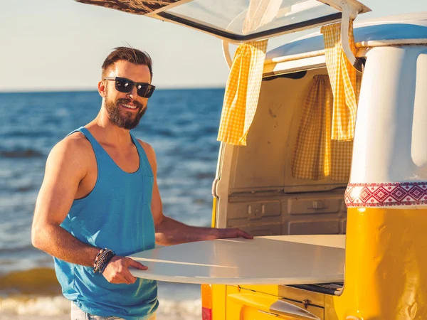 Hombre tomando skimboard fuera de coche tronco —  Fotos de Stock