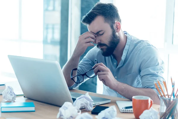 Frustrated young beard man massaging nose