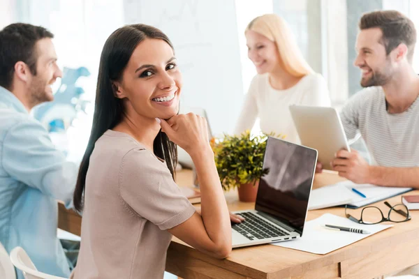 Mujer sentada junto con sus colegas — Foto de Stock