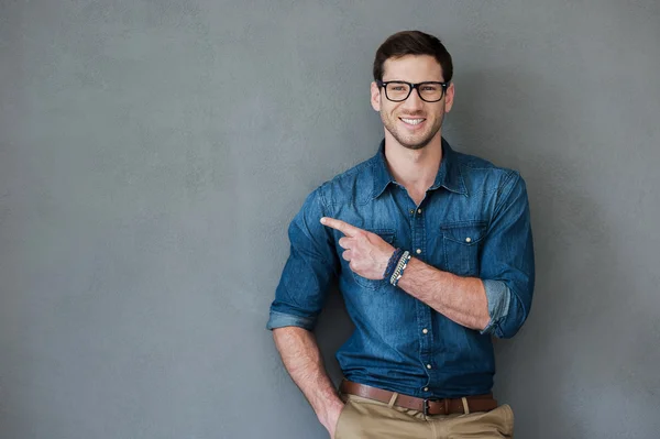 Joyful young man pointing away — Stock Photo, Image