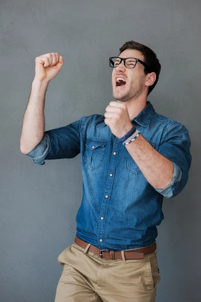 Excited man keeping arms raised — Stockfoto