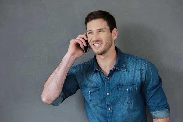 Cheerful young man talking on mobile phone — Stock Photo, Image