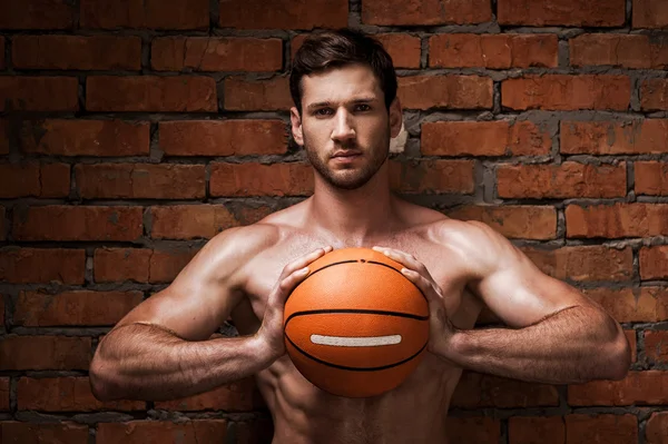 Homme musclé tenant ballon de basket — Photo