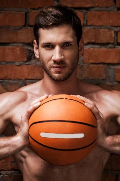 Muscular man holding basketball ball — Stock Photo, Image