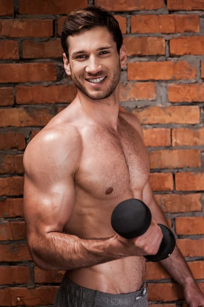 Muscular man training with dumbbells — Stock Photo, Image