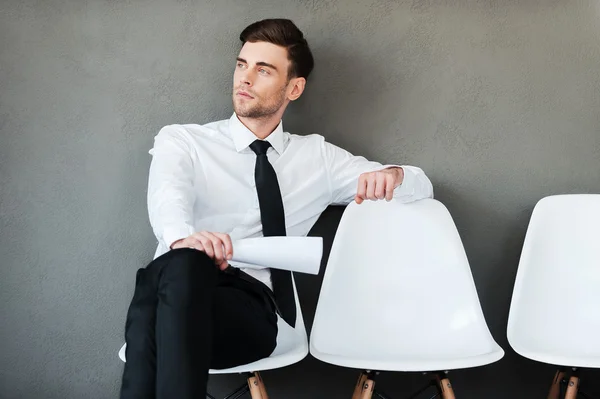 Thoughtful young man holding paper — Stock Photo, Image