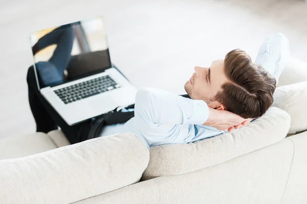 Geschäftsmann hält Laptop auf Beinen — Stockfoto