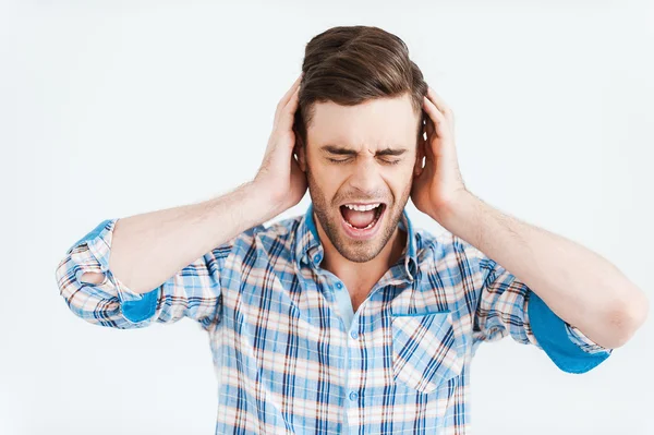 Frustrierter junger Mann hält Hände an Ohren — Stockfoto