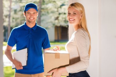 woman holding cardboard box with delivery man