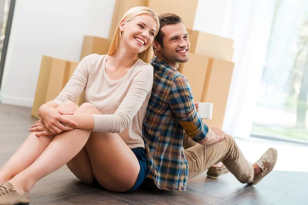 Casal sentado no chão de seu novo apartamento — Fotografia de Stock