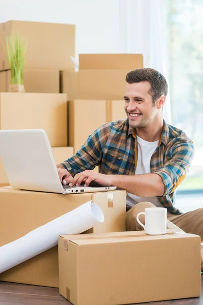 Mann sitzt auf dem Boden und arbeitet am Laptop — Stockfoto