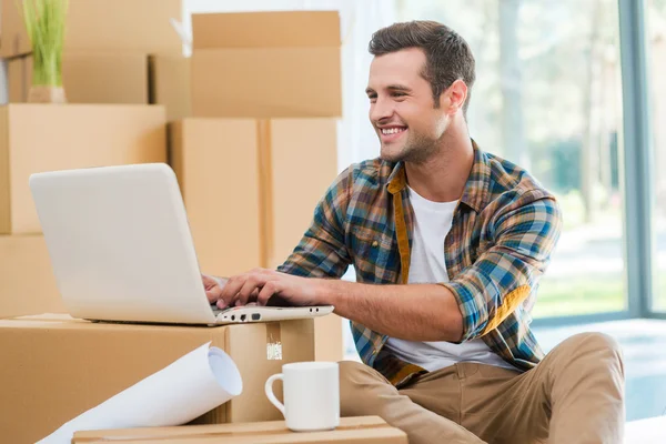 Homem sentado no chão e trabalhando no laptop — Fotografia de Stock