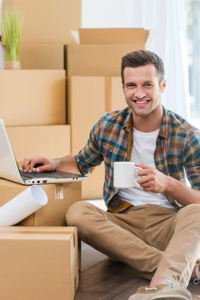 Mann sitzt auf dem Boden und arbeitet am Laptop — Stockfoto