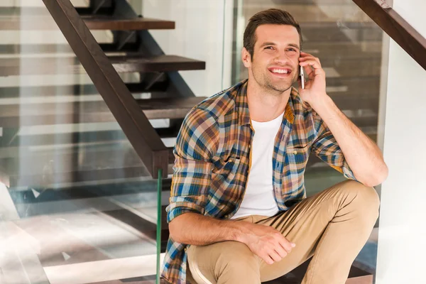 Man talking on phone while sitting on staircase — Stock Photo, Image