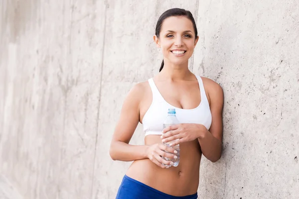 Woman in sports clothing holding bottle — 스톡 사진