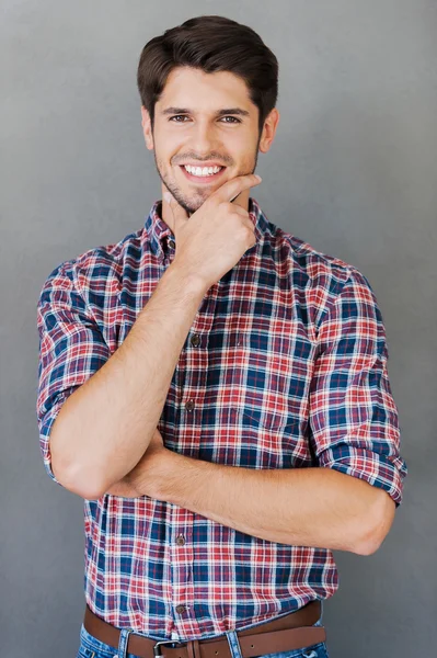 Cheerful young man holding hand on chin — Stockfoto