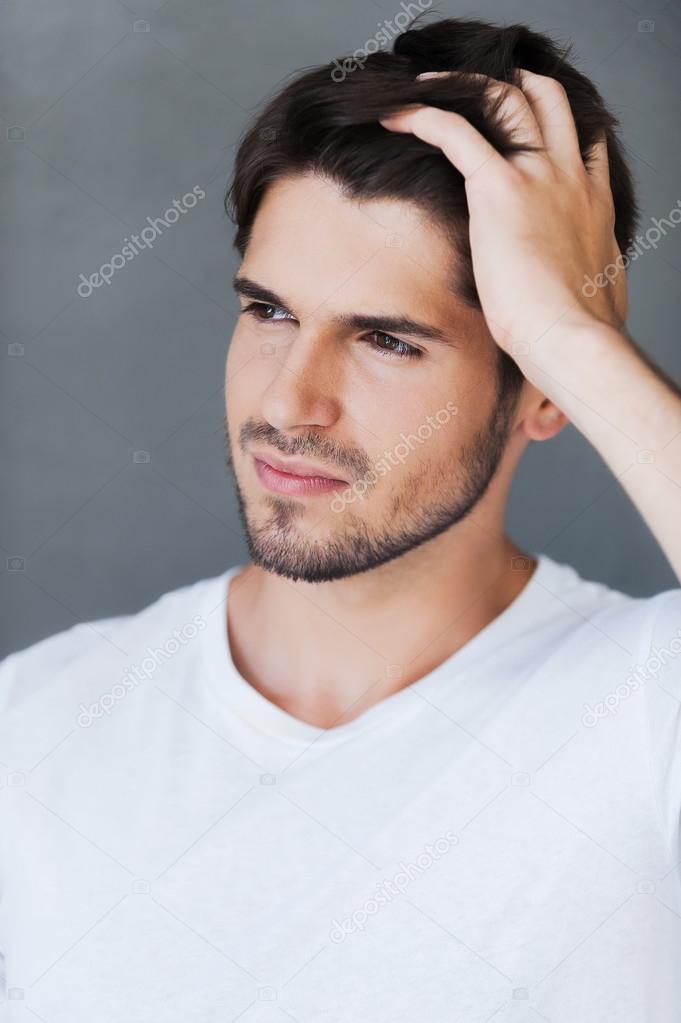young man holding hand in hair