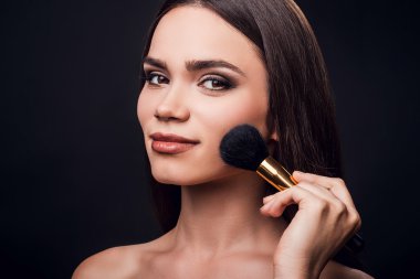 young woman holding make-up brush