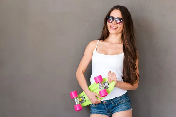 Smiling young woman holding skateboard — Stock Photo, Image