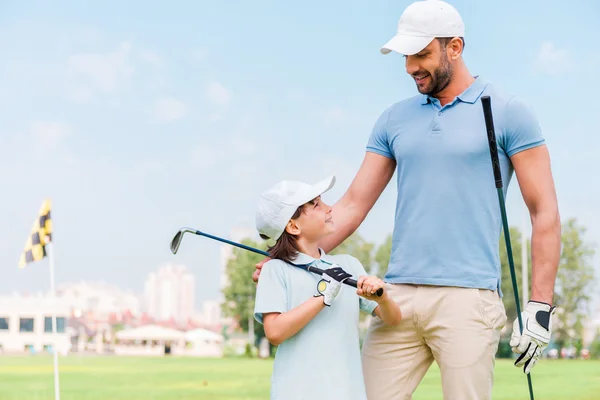 Homme et son fils tenant des clubs de golf — Photo