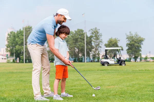 Man teaching his son to play golf — 스톡 사진