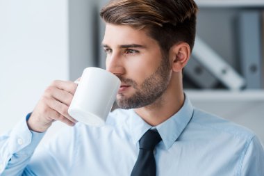 Kahve içme tişörtlü düşünceli adam