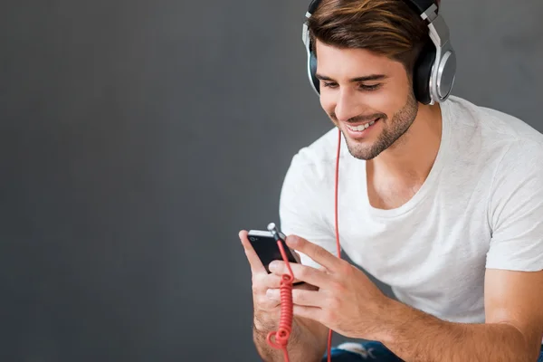 Jonge man in koptelefoon luisteren naar muziek — Stockfoto