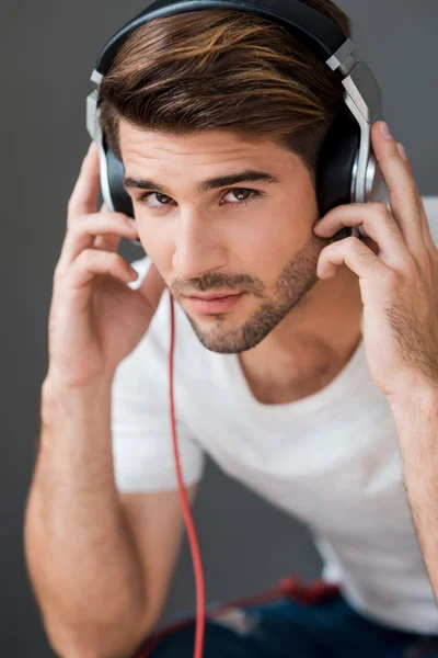 Человек в наушниках слушает музыку — стоковое фото