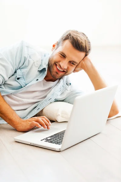 Man working on laptop and on floor — Stockfoto