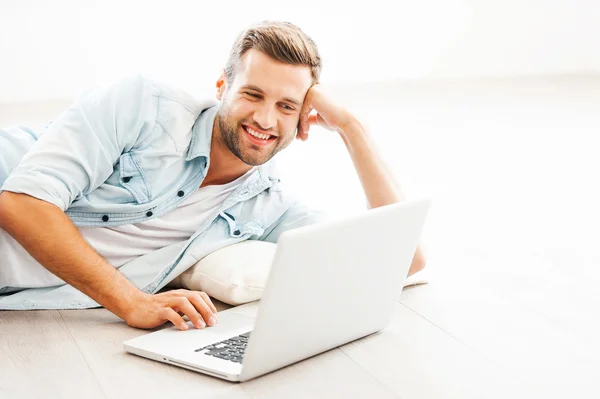 Hombre trabajando en el ordenador portátil y sonriendo — Foto de Stock