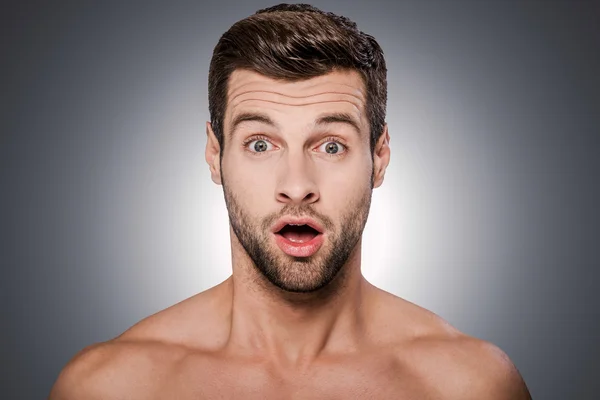 Surprised young shirtless man — Stockfoto