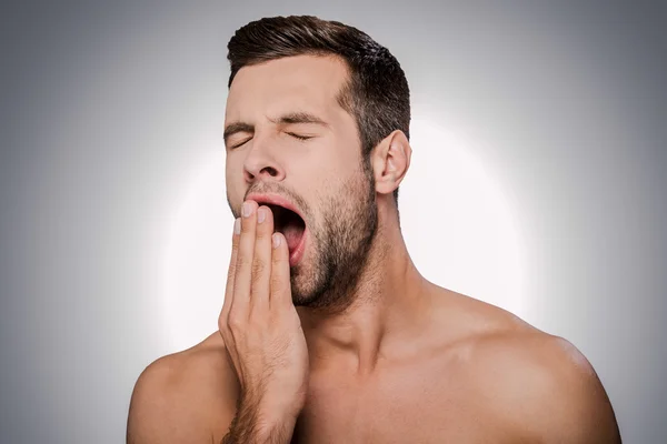 Man covering mouth by hand and yawning — Stock Photo, Image