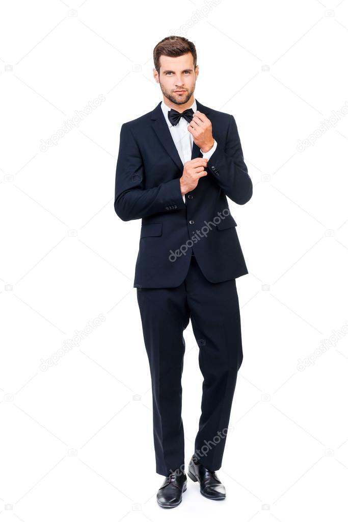 man in full suit and bow tie adjusting his sleeve