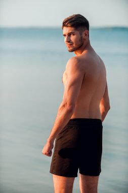 kaslı adam deniz kenarında ayakta