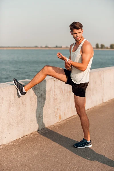 Muscular man warming up before running — Stock Photo, Image