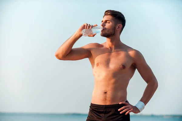 Muscular man drinking water — Stock Photo, Image