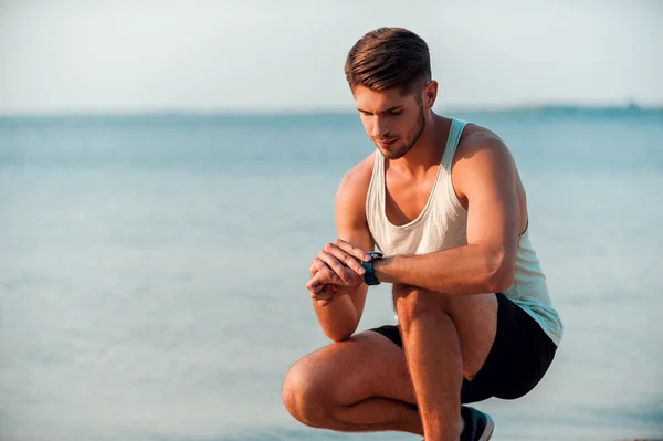 Homem muscular verificando o tempo em relógios — Fotografia de Stock