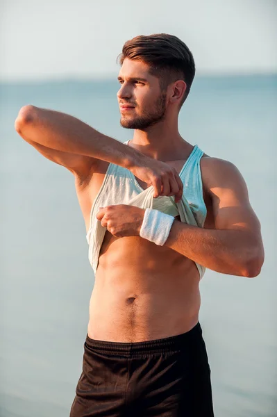 Hombre musculoso quitándose la camiseta —  Fotos de Stock