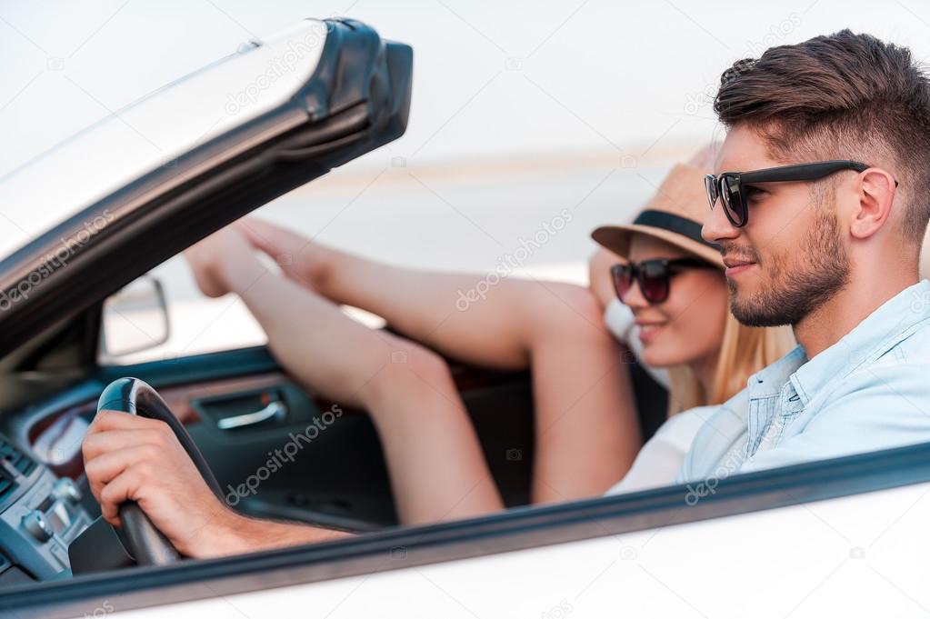 couple riding in their white convertible