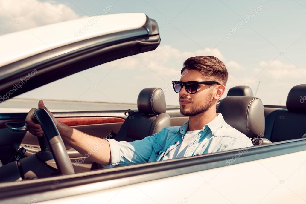 man driving his white convertible