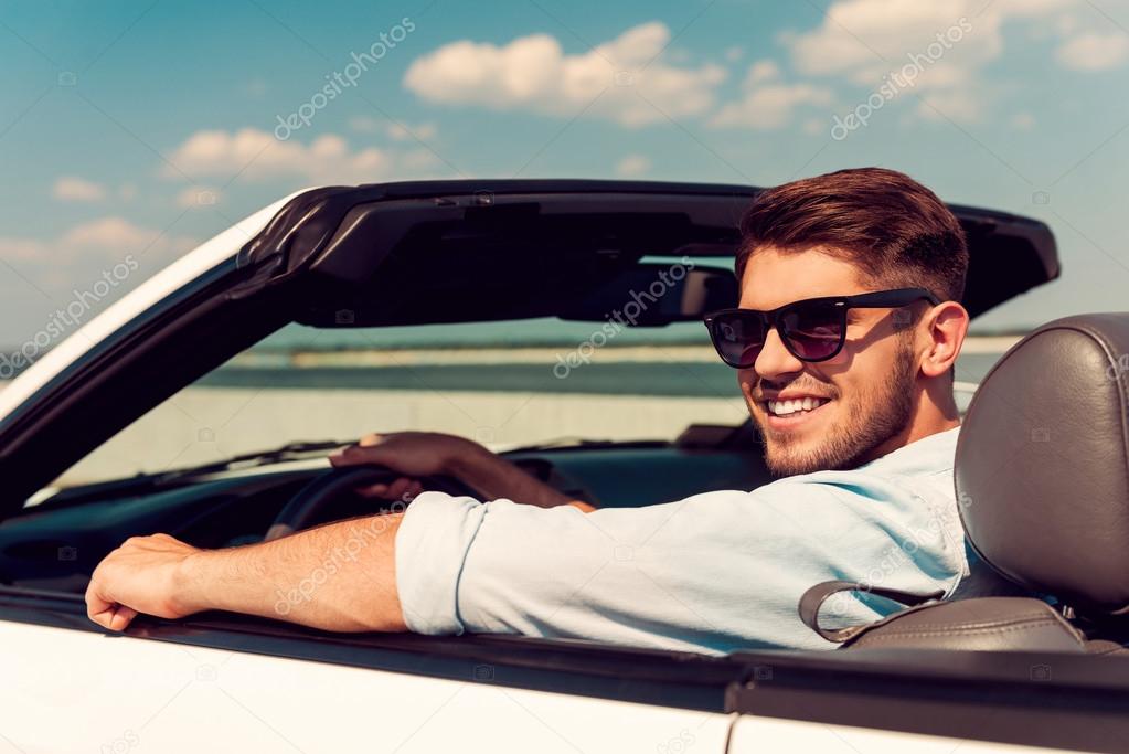 man looking over shoulder in convertible