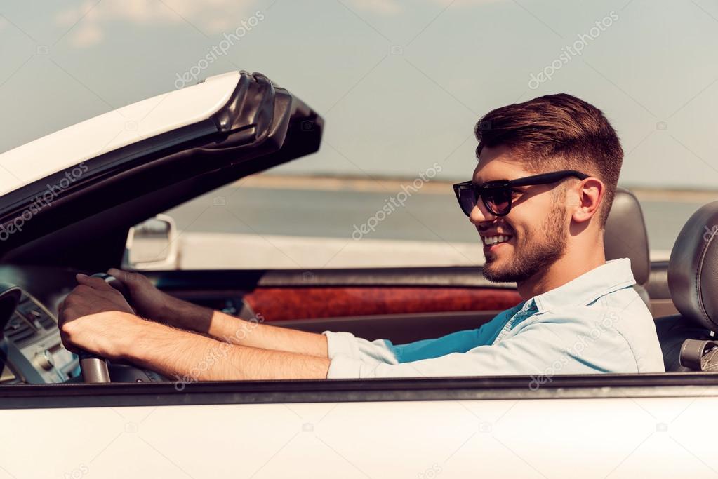 young man driving his white convertible