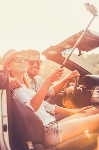 Casal fazendo selfie dentro de conversível — Fotografia de Stock