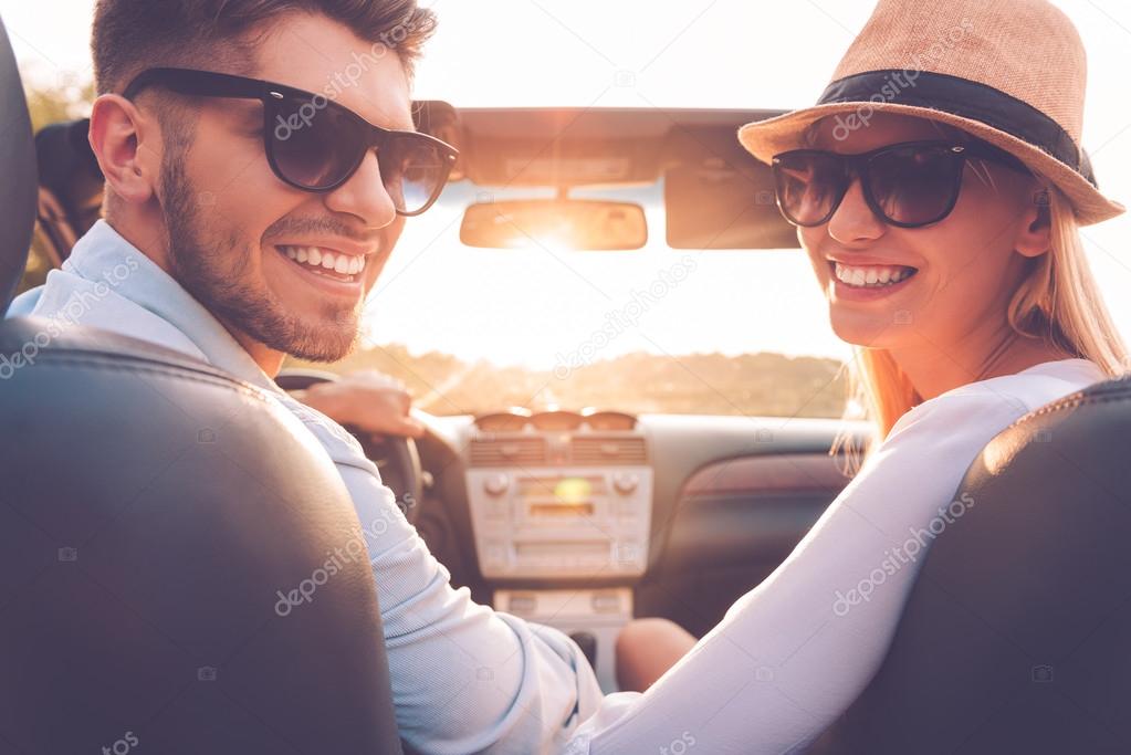 young couple sitting inside of convertible