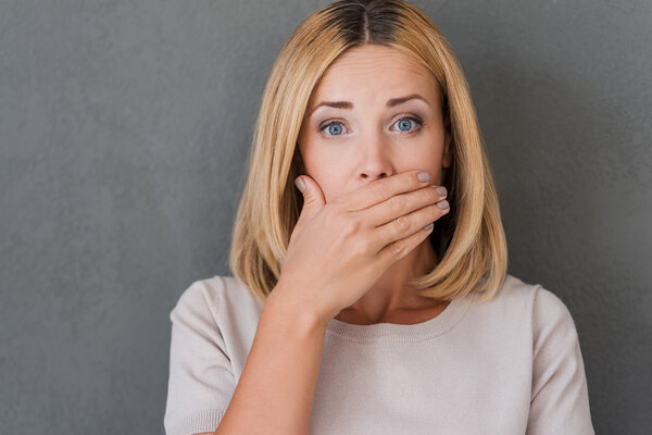 Surprised mature woman covering mouth
